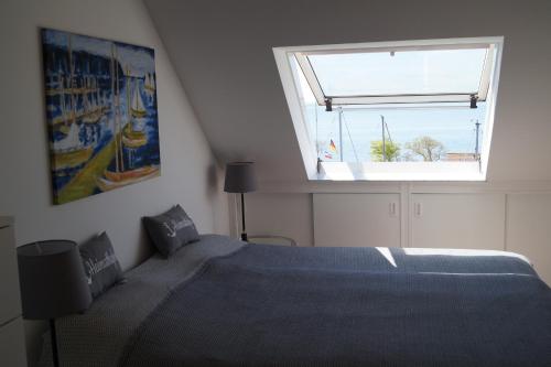 a bedroom with a large bed and a window at Fehmarn Ostseeferien FW3 Ferienwohnung "Toplicht" 1041 in Orth