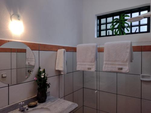 a bathroom with a sink and a mirror and towels at Suítes Brotas City in Brotas