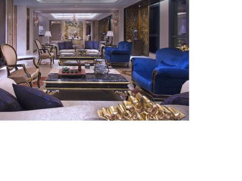 a living room with blue chairs and couches at Wanda Vista Tianjin in Tianjin