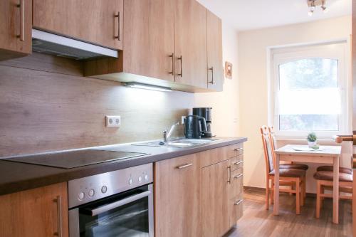 a kitchen with a sink and a stove and a table at Familienhof Brüning - Terrassenwohnung in Meppen