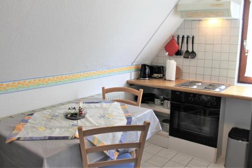 a kitchen with a table and two chairs and a stove at Haus Uschi - Ferienwohnung in Cismar