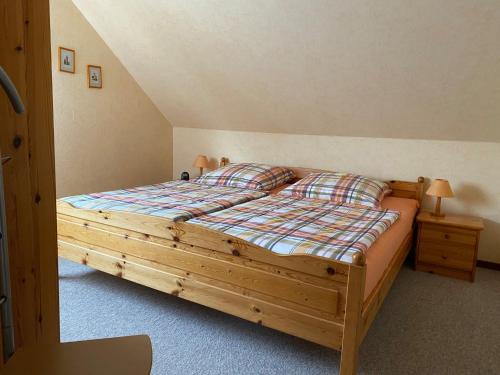 ein Schlafzimmer mit einem Holzbett in einem Zimmer in der Unterkunft Kreutzmann Ferienwohnung für einen erholsamen Urlaub in ruhiger, zentraler Lage in Heiligenhafen