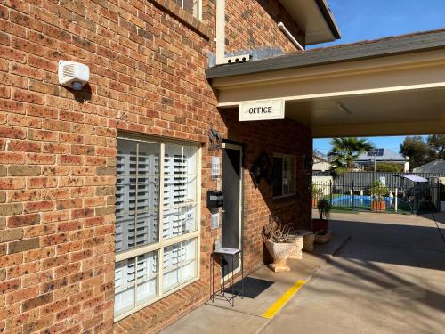 a brick building with a street sign on it at All Settlers Motor Inn Parkes in Parkes