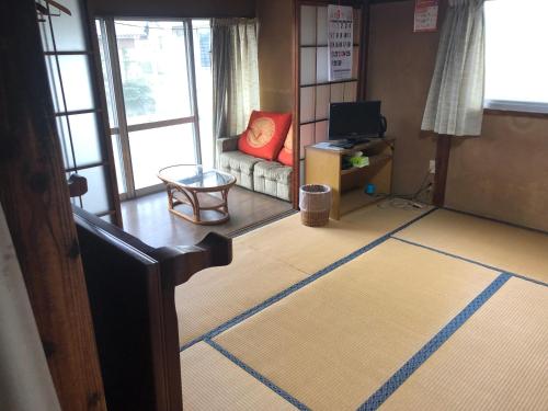 a living room with a couch and a television at 竜ケ崎駅そばの森田屋旅館 in Ryūgasaki