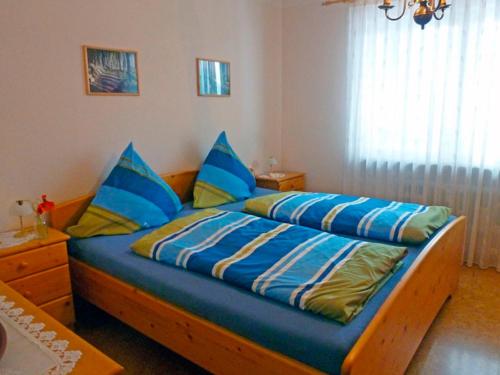 a bedroom with a bed with blue comforter and blue pillows at Kappel App 21 in Lenzkirch