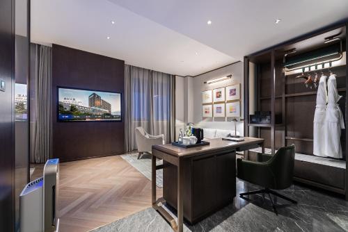 a hotel room with a desk and a tv at Novotel Xian Xixian in Xi'an