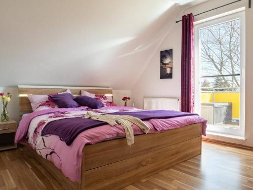 a bedroom with a bed with purple sheets and a window at Wiesenstraße 2 Whg 2 in Zingst