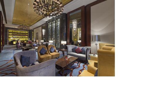 a lobby with couches and chairs and a chandelier at Wanda Vista Tianjin in Tianjin
