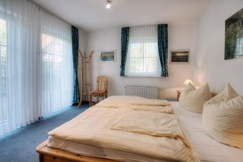 a bedroom with a large bed and two windows at Strandkieker 14, PP innen in Zingst