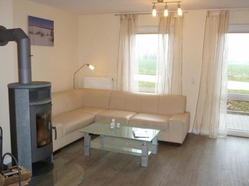 a living room with a couch and a wood stove at Fehmarnstrand 78 RH 6 in Staberdorf