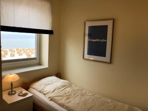 ein kleines Schlafzimmer mit einem Bett und einem Fenster in der Unterkunft Surfer in Laboe