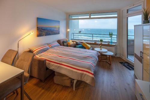 a bedroom with a bed with a view of the ocean at Strandhotel Seeblick 66 in Dahme