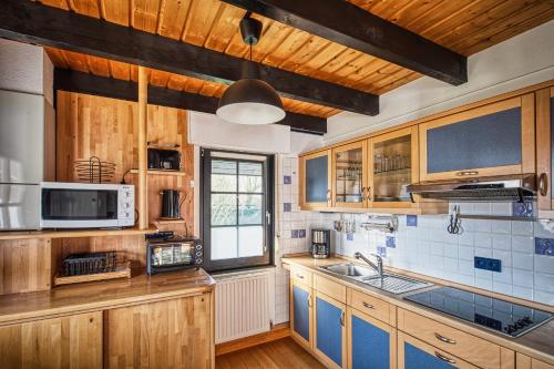 a kitchen with wooden cabinets and a sink at Ferienhaus Hygge in Kappeln