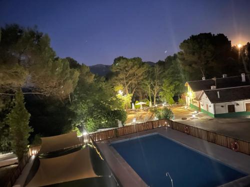 a swimming pool in a backyard at night at Albergue Hospedería Montaña Morciguillinas in Cortijos Nuevos