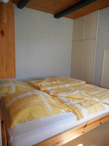 Bisdorf的住宿－Ferienhof Bisdorf "Schwülkennest" Reihenhaus，床上有黄色的毯子