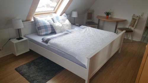 ein weißes Bett in einem Zimmer mit Fenster in der Unterkunft Ferienwohnung Vetter in Loose