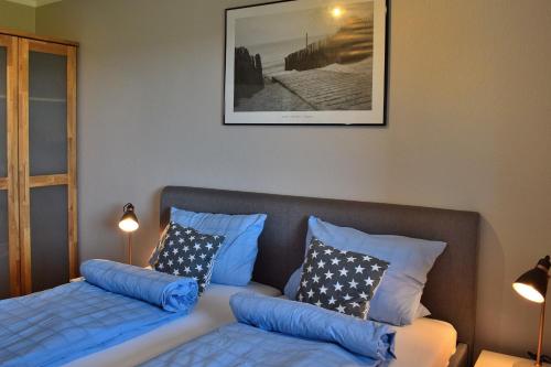 Cette chambre comprend un lit avec des oreillers bleus et un canapé. dans l'établissement Fehmarnstrand 77 Whg 3, à Staberdorf
