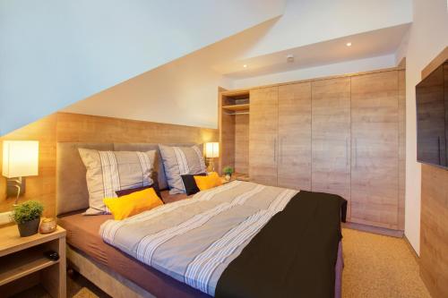 a bedroom with a large bed with a wooden wall at Forest 306 in Feldberg