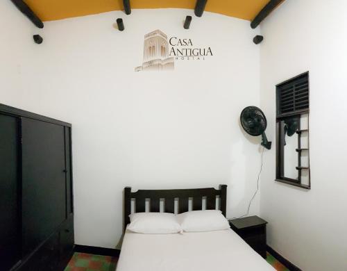 a bedroom with a bed and a sign on the wall at Hotel Boutique Casa Antigua in San Vicente de Chucurí