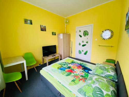 a bedroom with a bed and a desk and a television at Bon Voyage Apartments in Gdańsk
