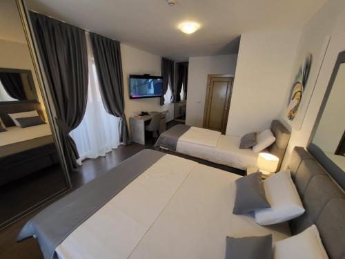 a hotel room with two beds and a couch at Olympic Wellness & Spa Apartments in Belgrade