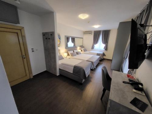 a hotel room with two beds and a flat screen tv at Olympic Wellness & Spa Apartments in Belgrade