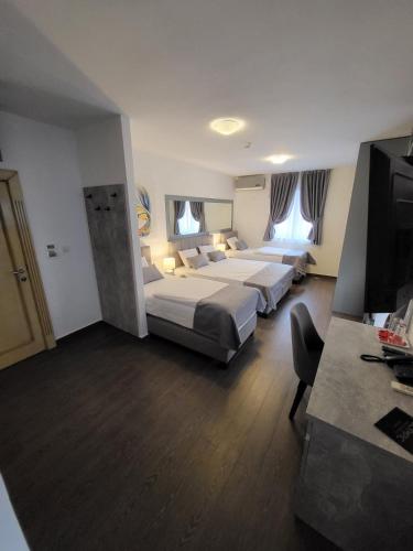 a hotel room with two beds and a flat screen tv at Olympic Wellness & Spa Apartments in Belgrade