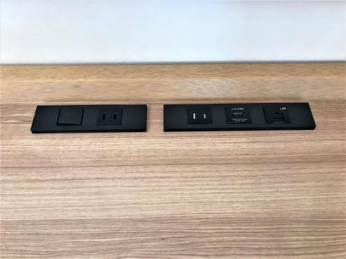 two digital clocks sitting on top of a wooden table at Libre Garden Hotel in Naha