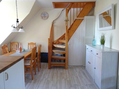 a kitchen and dining room with a spiral staircase at Muschelkoje in Stakendorfer Strand