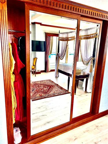 a mirror with a reflection of a bedroom at Riviera Hotel in Dubai