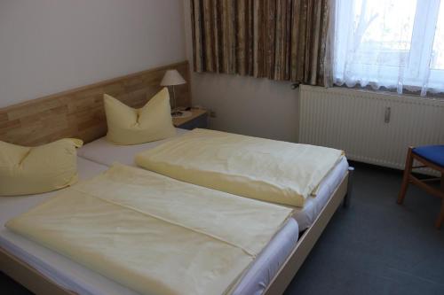 ヴェルニゲローデにあるFerienwohnung 4のベッドルーム1室(黄色い枕のベッド2台付)