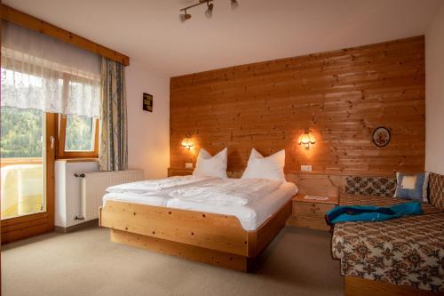 a bedroom with a bed and a wooden wall at Christof,s Ferienwohnung WILD230 in Oberau