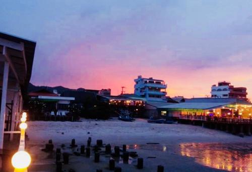 a group of buildings with a sunset in the background at Karoon Sea View Lodge in Hua Hin
