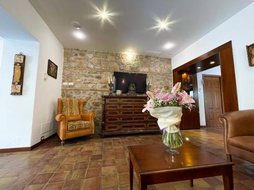 a living room with a vase of flowers on a table at Hotel La Plumeria in Cefalù