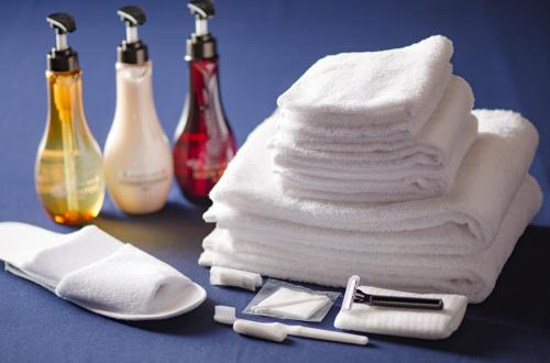 a pile of towels with a razor and a stack of towels at Hotel Tokyo Garden Palace in Tokyo