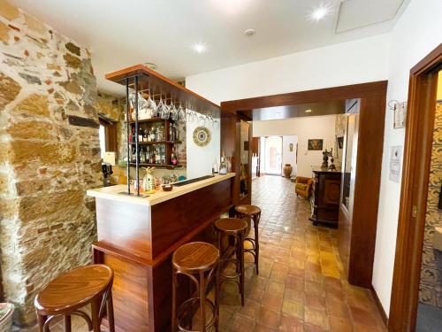 a bar with stools in a room with a stone wall at Hotel La Plumeria in Cefalù