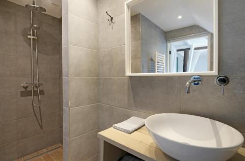a bathroom with a white sink and a shower at Daaldersplek Bantega in Bantega