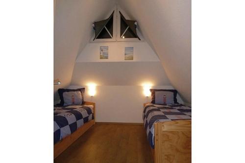 ツィングストにあるSonnenhus Zingstの天井の屋根裏部屋で、ベッド2台が備わります。