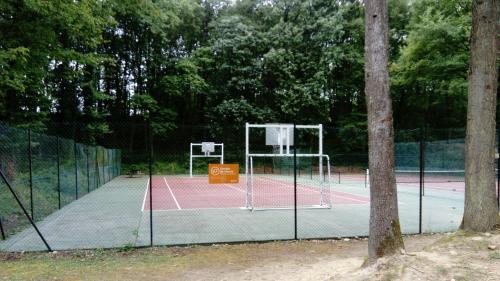 un panier de basket sur un court de tennis avec des arbres dans l'établissement Mobile-home, à Saint-Chéron
