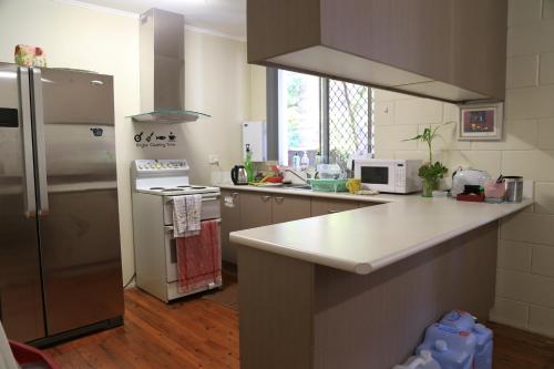 a kitchen with a refrigerator and a counter top at Pure Land Guest House in Toowoomba