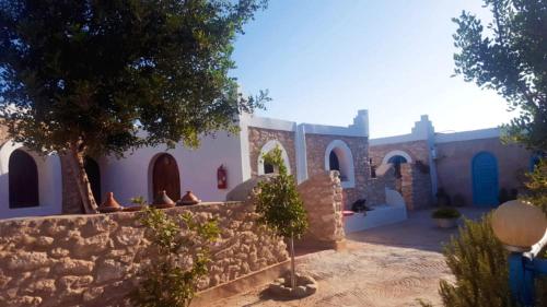un edificio con una pared de piedra y un patio en Ranch de Sidi kaouki, en Essaouira