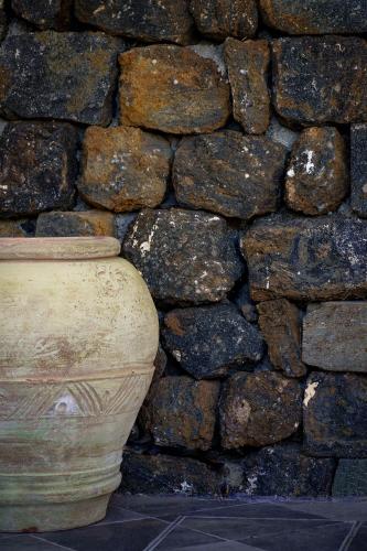 a stone wall with a vase in front of a rock wall at Venus Dream in Pantelleria