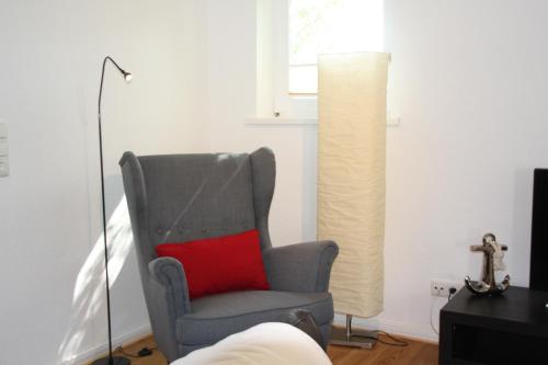 - Silla con almohada roja en la sala de estar en Feldlerche, en Neue Tiefe Fehmarn