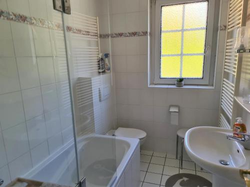 a bathroom with a tub and a toilet and a sink at Bootshaus, App 1 in Grömitz