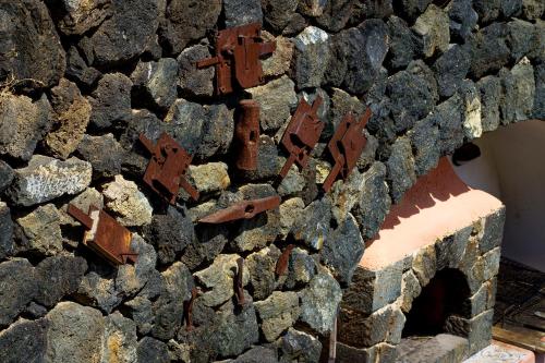a stone wall with rusty iron pieces on it at Venus Dream in Pantelleria