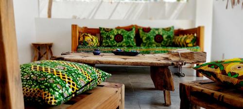 a room with a table and pillows and a couch at Namayani apartment in Pwani Mchangani