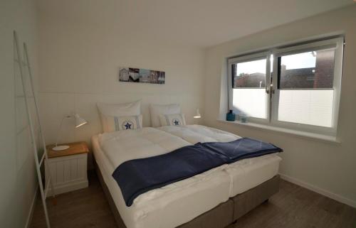 a bedroom with a large bed and a window at Skagen in Kronsgaard