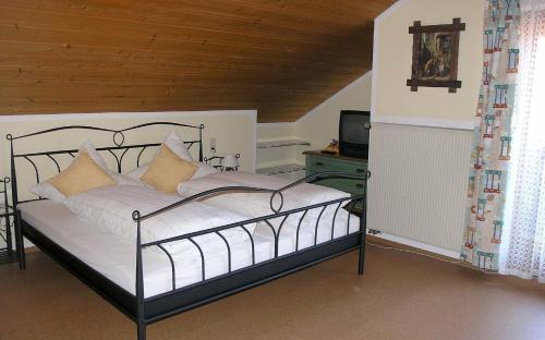 a bedroom with a metal bed with white sheets and pillows at Ferienwohnung Nr 3, Lechbruck-Prem, Allgäu in Prem