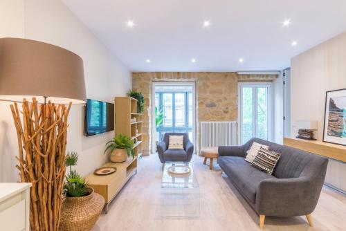 a living room with a couch and a chair at Apartamentos Bellas Artes in San Sebastián