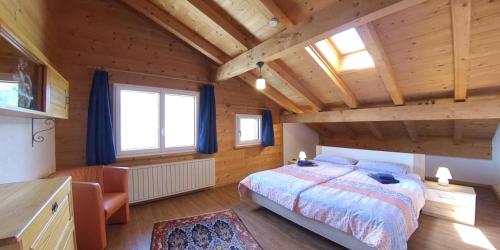 - une chambre avec un lit dans une pièce dotée de murs en bois dans l'établissement Ferienhaus Maliet, à Luzein